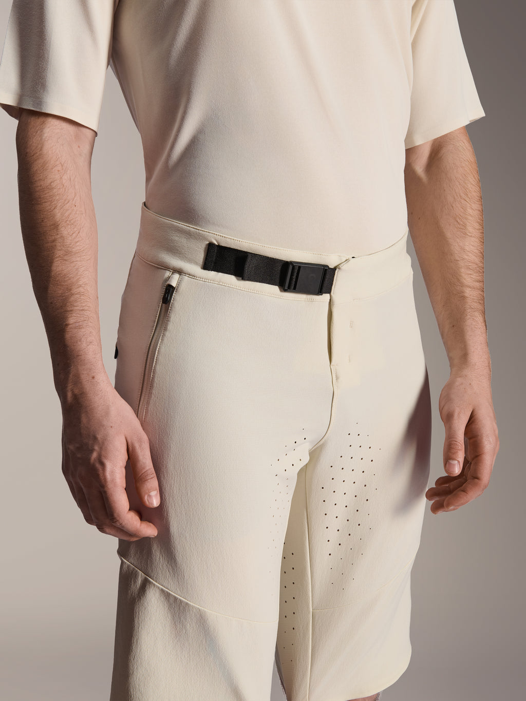 Alpinestars A-Aria Elite Shorts, pantaloncini da mountain bike, colore Ecru, vista ravvicinata della chiusura con fibbia magnetica nera, tasca laterale con zip e ventilazione tagliata al laser, abbigliamento tecnico da ciclismo