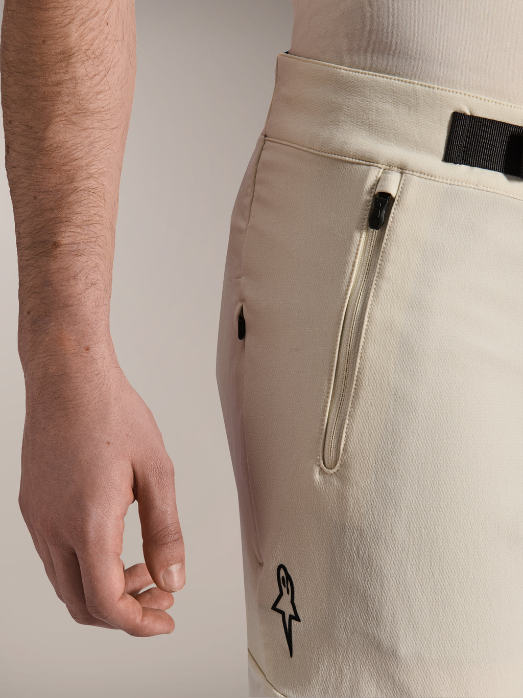Alpinestars A-Aria Elite Shorts, pantaloncini da mountain bike, ecru, vista laterale ravvicinata che mostra la tasca con zip e la chiusura con fibbia magnetica, abbigliamento tecnico da ciclismo con accenti neri