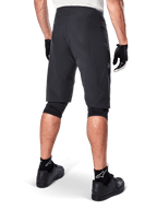 Alpinestars Pantaloncini A-Aria, pantaloncini da mountain bike, nero, vista posteriore che mostra la vestibilità performante e il design essenziale, indossati con guanti neri e calze con il logo Astars bianco, abbigliamento tecnico da ciclismo per fuoristrada