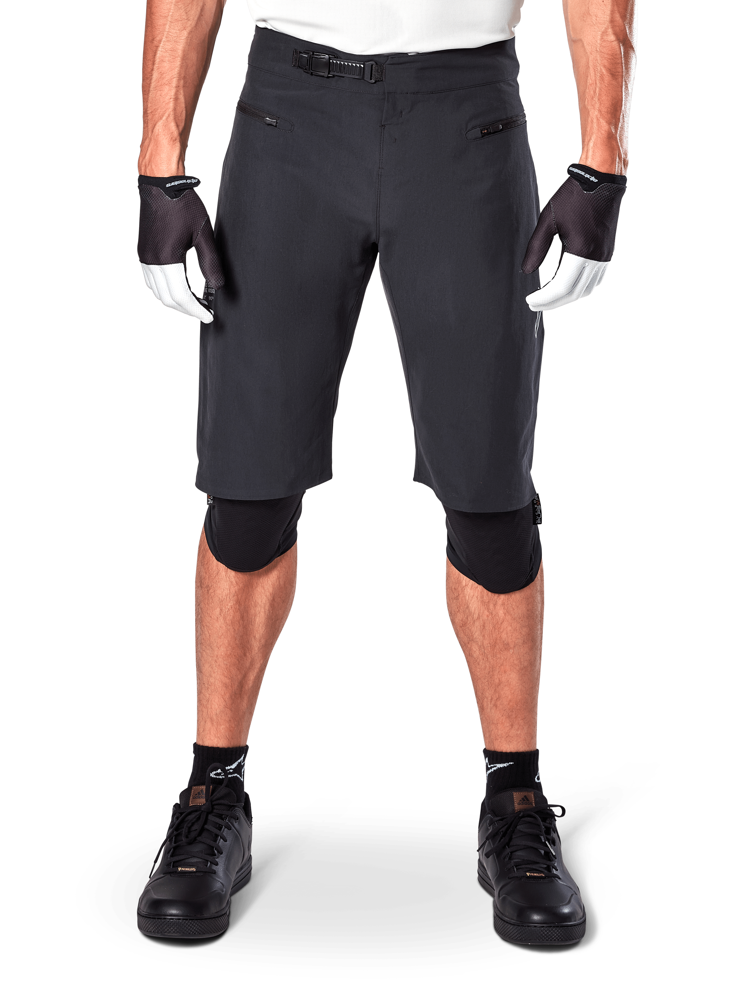 Pantaloncini Alpinestars A-Aria, pantaloncini da mountain bike neri, con chiusura a cricchetto in vita e tasche con cerniera, indossati con guanti bianchi e neri e ginocchiere, abbigliamento tecnico da ciclismo per il fuoristrada