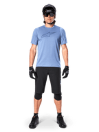Alpinestars Pantaloncini A-Dura Elite, pantaloncini da mountain bike neri, indossati con una t-shirt azzurra, casco nero, occhiali da sole e ginocchiere, abbigliamento professionale per ciclismo fuoristrada