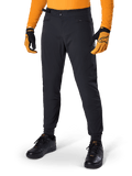 Alpinestars A-Dura Pants, pantaloni da mountain bike, nero, regolatori laterali in vita e tasche con zip, indossati con maglia e guanti arancioni, vestibilità regular sportiva per la guida MTB