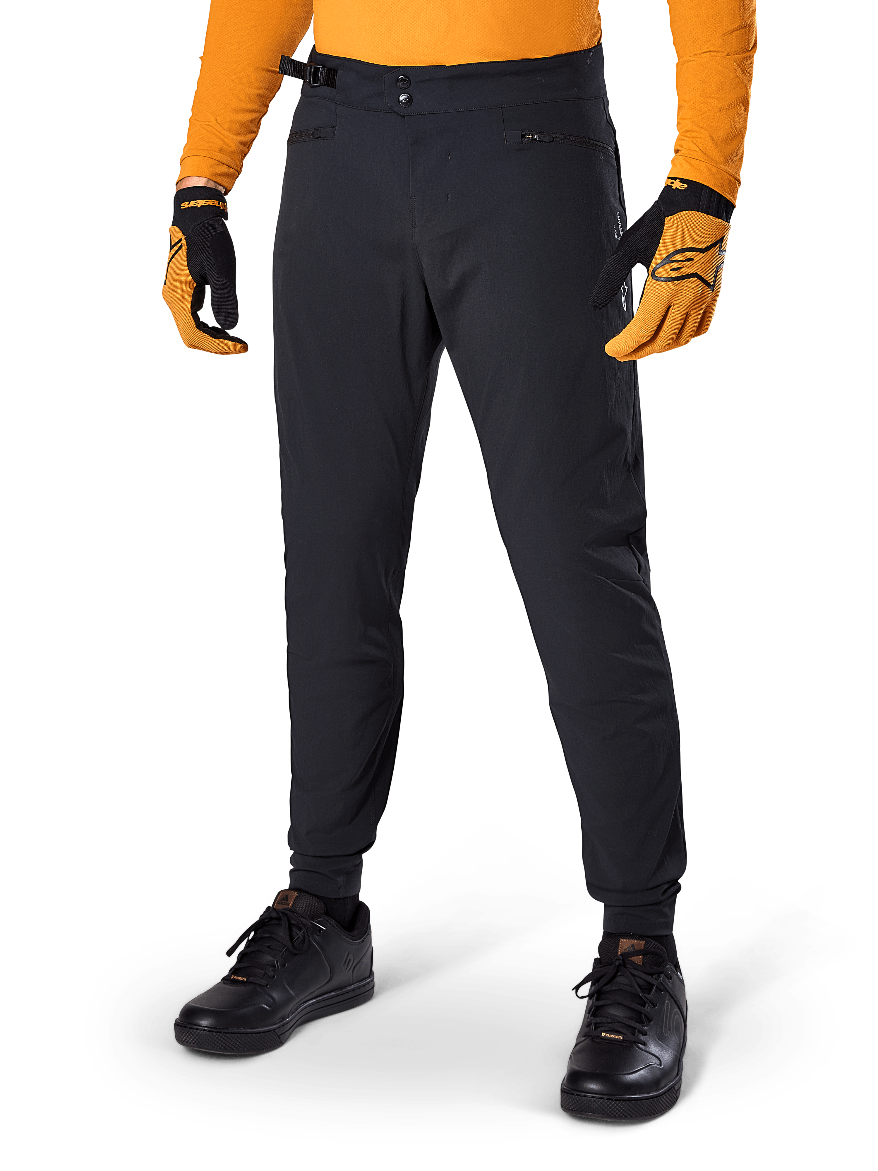 Alpinestars A-Dura Pants, pantaloni da mountain bike, nero, regolatori laterali in vita e tasche con zip, indossati con maglia e guanti arancioni, vestibilità regular sportiva per la guida MTB