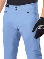 Alpinestars A-Dura Pants, pantaloni da ciclismo MTB, Infinity Blue, primo piano della vita con doppia chiusura a scatto e regolatore laterale, tasche con cerniera, indossati con guanti Alpinestars neri