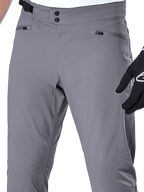 Pantaloni Alpinestars A-Dura, pantaloni MTB, grigio scuro, primo piano della zona vita con doppia chiusura a scatto, regolatore laterale e tasche con zip, tessuto elasticizzato resistente per mountain bike