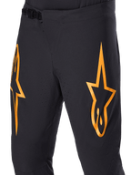 Alpinestars A-Supra Race Pants, pantaloni da ciclismo MTB, neri con grandi loghi a stella arancioni, chiusura a cricchetto frontale e fori di ventilazione traforati al laser, design tecnico