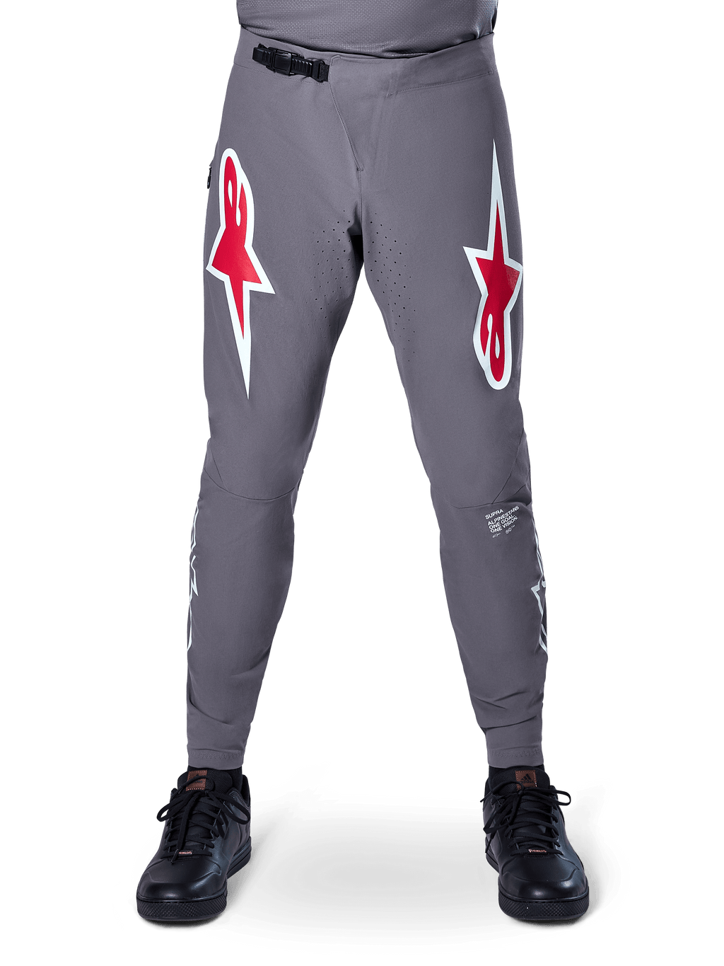Alpinestars A-Supra Race Pants, pantaloni da gara MTB, grigio scuro, caratterizzati da grandi loghi a stella rossi e bianchi sulle cosce, ventilazione traforata al laser sull'interno gamba e chiusura in vita a cricchetto nera, progettati per le gare di mountain bike.