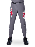 Alpinestars A-Supra Race Pants, pantaloni da gara MTB, grigio scuro, caratterizzati da grandi loghi a stella rossi e bianchi sulle cosce, ventilazione traforata al laser sull'interno gamba e chiusura in vita a cricchetto nera, progettati per le gare di mountain bike.