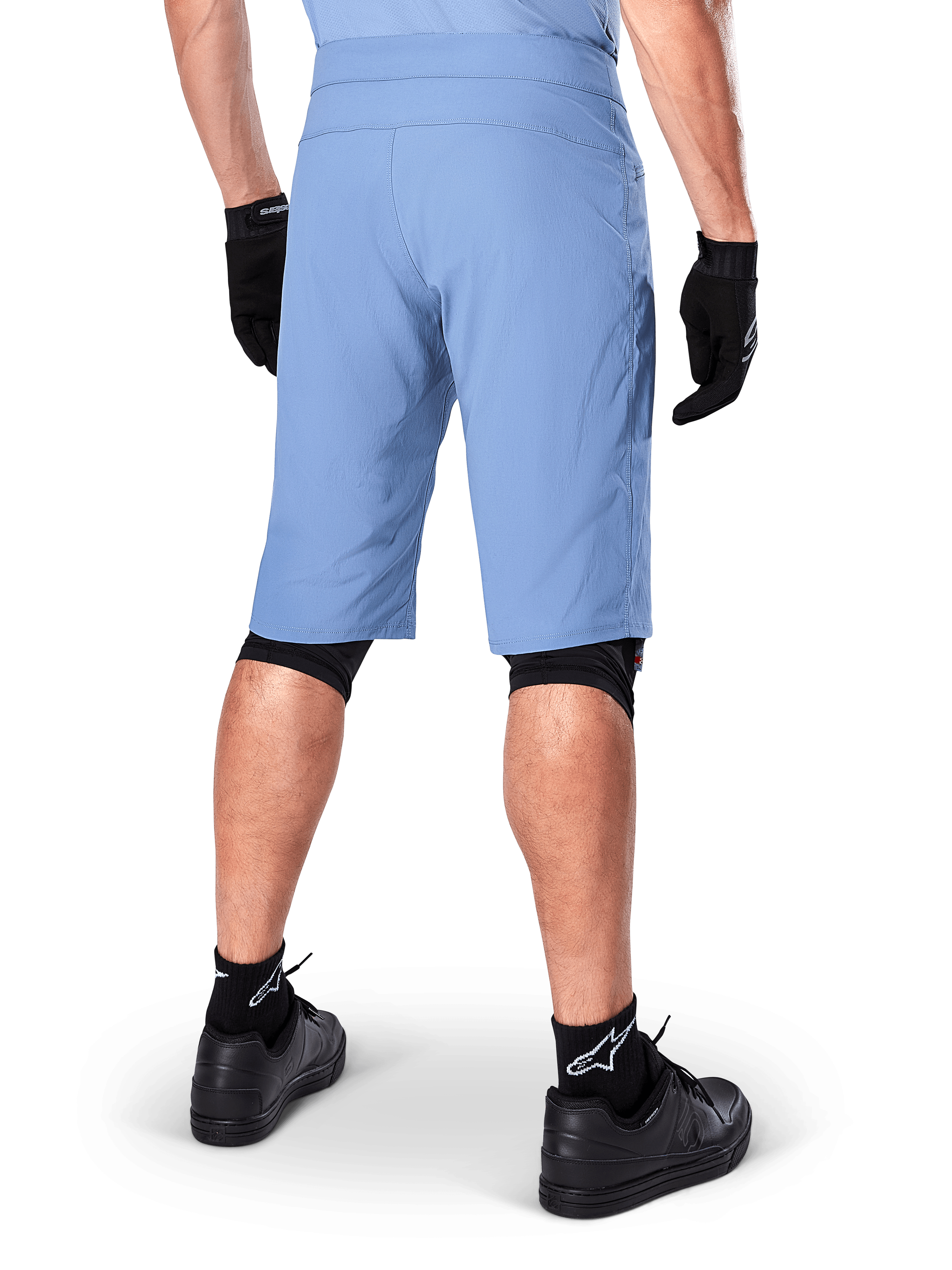 Alpinestars A-Dura Shorts, pantaloncini da mountain bike Infinity Blue, vista posteriore, abbinati a guanti neri, knee liners e calze nere con logo a stella bianco, materiale elastico resistente per ciclismo fuoristrada