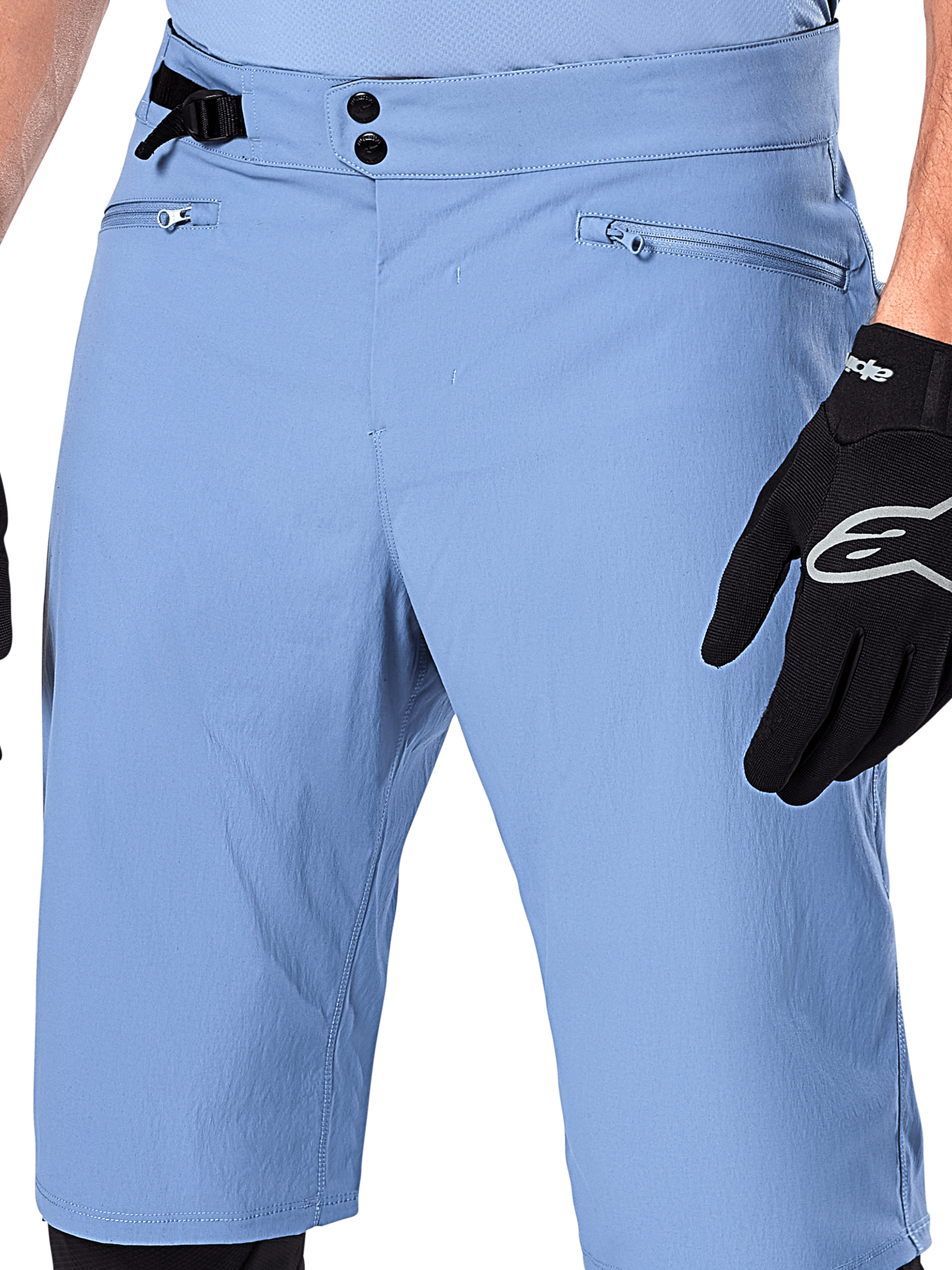 Pantaloncini Alpinestars A-Dura, shorts da mountain bike in Infinity Blue, primo piano della vita con chiusura a doppio scatto, regolazione laterale e tasche con zip foderate in rete, indossati con un guanto Alpinestars nero