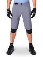 Alpinestars A-Dura Shorts, pantaloncini da mountain bike, grigio scuro, indossati con guanti e ginocchiere Alpinestars neri, caratterizzati da chiusura a doppio scatto e tasche foderate in rete con zip, tessuto resistente elasticizzato in 2 direzioni per il ciclismo fuoristrada