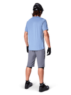 Alpinestars A-Dura Shorts, pantaloncini MTB grigio scuro, vista posteriore, indossati con maglia azzurra a maniche corte e casco da mountain bike nero, guanti e calze neri con scarpe nere, abbigliamento funzionale e resistente per il ciclismo off-road
