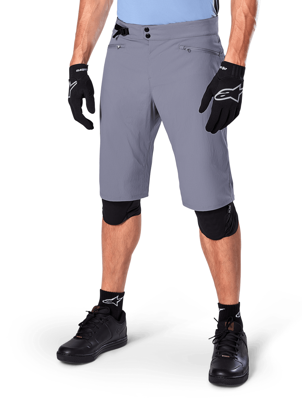 Alpinestars Shorts A-Dura, pantaloncini da mountain bike grigio scuro, abbinati a guanti e ginocchiere neri, con tasche con zip e chiusura a doppio scatto, abbigliamento robusto da ciclismo per percorsi off-road