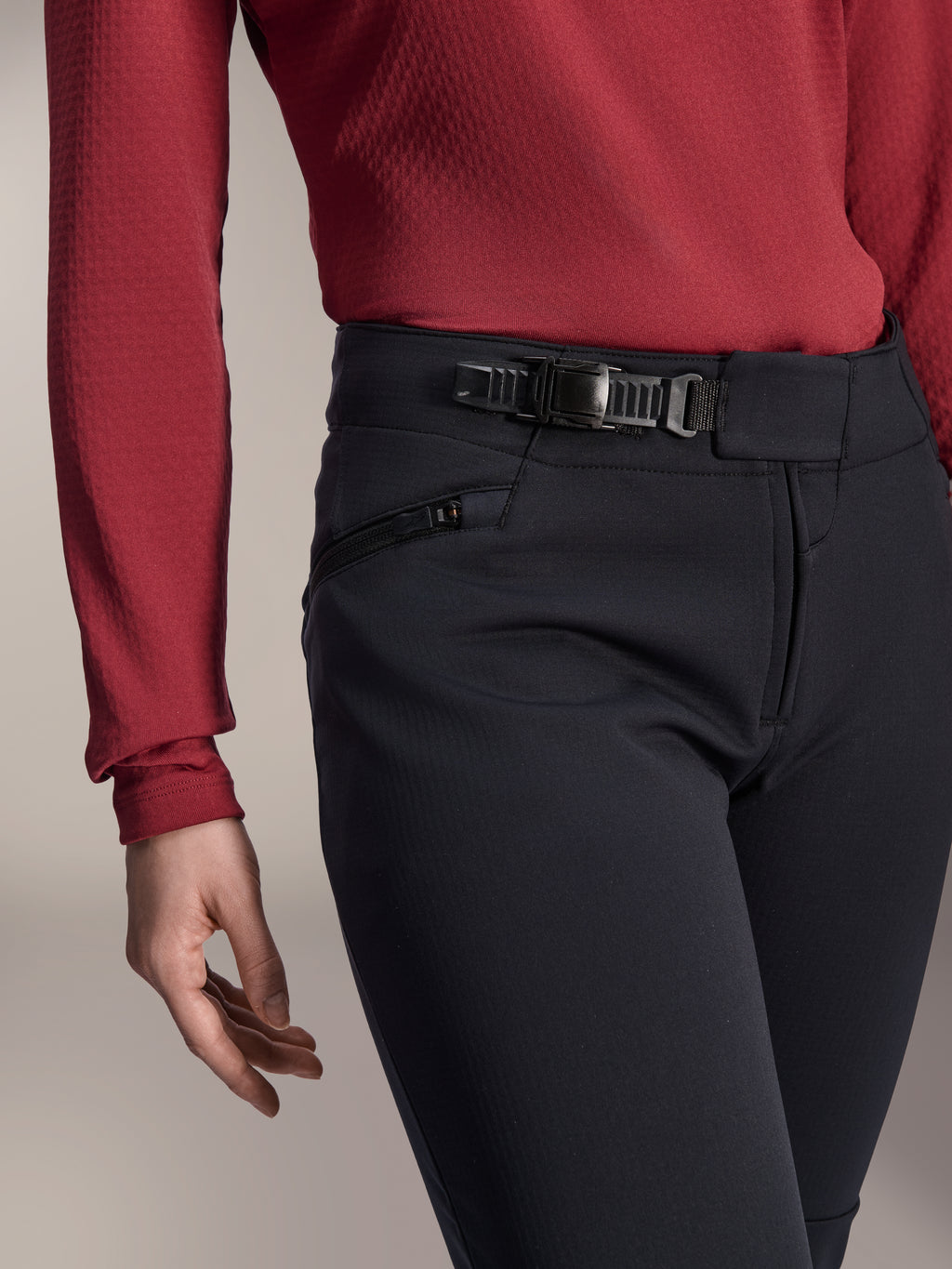 Alpinestars Stella A-Dura Thermal Pant, pantaloni da MTB da donna, nero, primo piano che mostra il sistema di chiusura a cricchetto sulla fascia in vita e la tasca laterale con cerniera, indossati con una maglia a maniche lunghe rosso scuro, abbigliamento resistente per trail riding in condizioni fredde