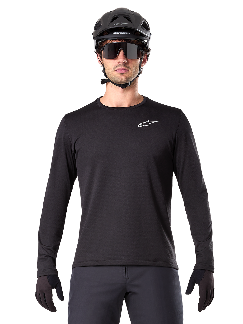 Alpinestars A-Dura Thermal Jersey, maglia da mountain bike a maniche lunghe nera, indossata con casco nero e grandi occhiali da sole, con un piccolo logo Alpinestars bianco sul petto, vestibilità regolare, abbigliamento da ciclismo MTB