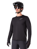 Alpinestars A-Dura Thermal Jersey, maglia da mountain bike a maniche lunghe nera, logo bianco sul petto, indossata con casco e guanti neri, design sportivo e lineare per trail riding