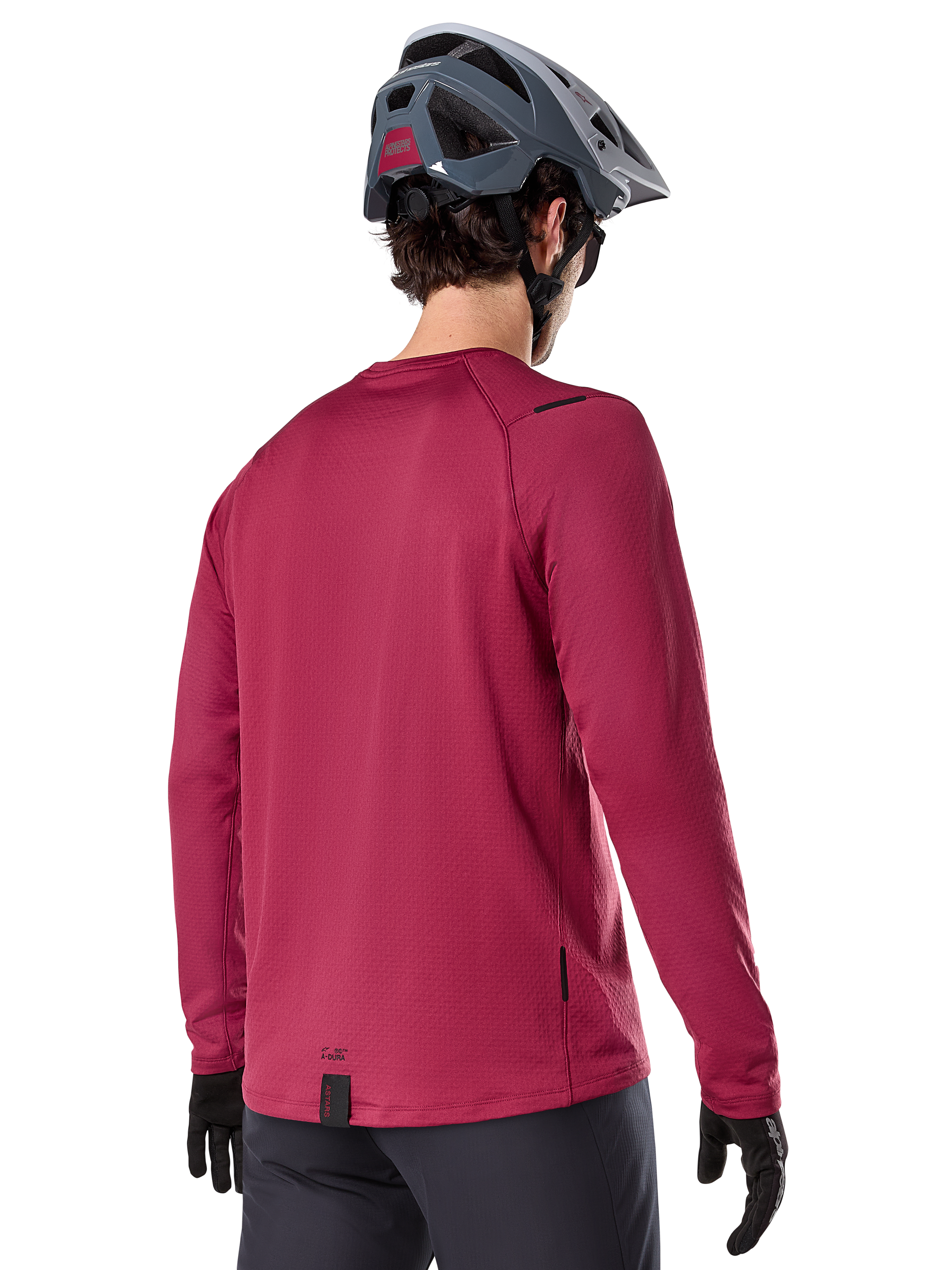 Alpinestars A-Dura Thermal Jersey, maglia da mountain bike a maniche lunghe, bordeaux, vista posteriore su modello con casco da MTB grigio e guanti neri, con coda allungata e piccoli dettagli del logo, progettata per il trail riding in climi freddi