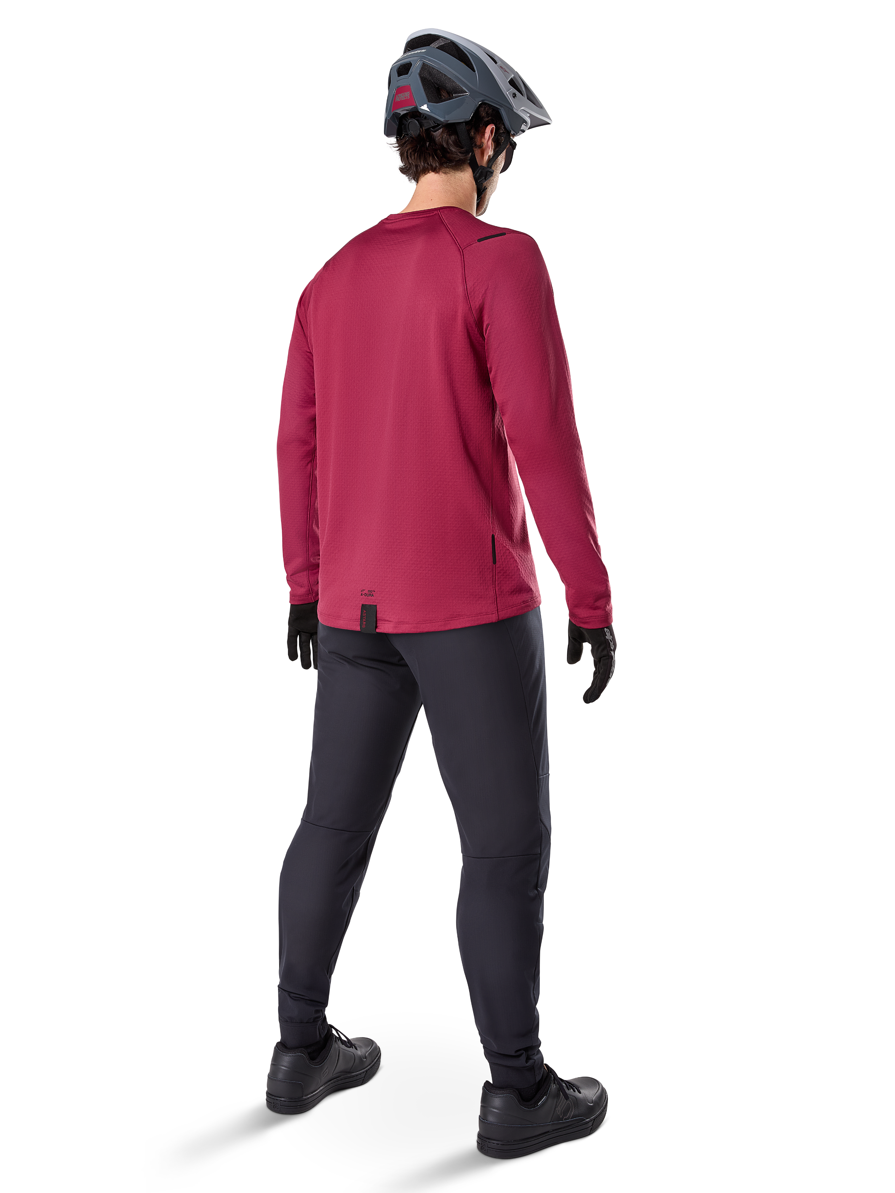 Alpinestars A-Dura Thermal Jersey, maglia da ciclismo a maniche lunghe bordeaux, vista posteriore, indossata con pantaloni da mountain bike neri e casco grigio, con bordo posteriore allungato per una maggiore copertura, equipaggiamento da mountain bike per climi freddi
