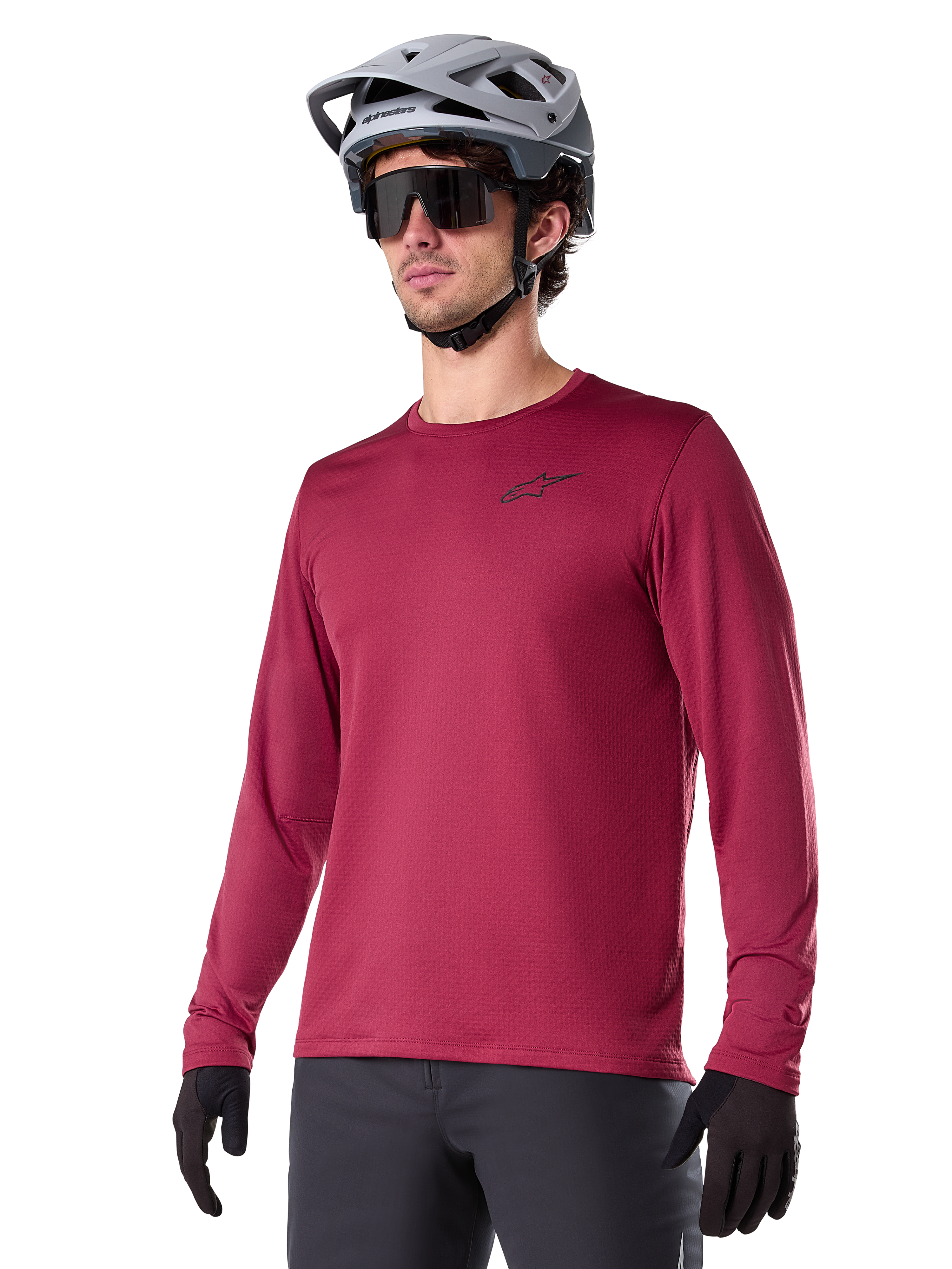 Alpinestars A-Dura Thermal Jersey, maglia da mountain bike a maniche lunghe, rosso burgundy, con fodera in pile isolante e piccolo logo nero sul petto, indossata con casco grigio, occhiali da sole neri e guanti neri, progettata per il ciclismo in climi freddi