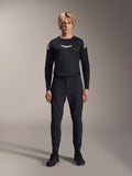 Alpinestars A-Aria Elite Pants, pantaloni da MTB Black Titanium, indossati da un modello con maglia a maniche lunghe coordinata e sneakers, design slim-fit performante con chiusura a fibbia magnetica, abbigliamento tecnico da mountain bike