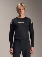 Alpinestars A-Aria Polartec Elite Jersey, maglia MTB a maniche lunghe, nera, con logo 'astars' bianco sul petto e grafiche bianche sulle spalle, abbigliamento tecnico da ciclismo indossato da un modello