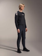 Modello che indossa la maglia Alpinestars A-Aria Polartec Elite a maniche lunghe in nero, abbinata a pantaloni tecnici da mountain bike neri coordinati e scarpe nere, abbigliamento da ciclismo performante per il fuoristrada, scatto in studio.