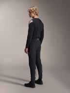 Pantaloni Alpinestars A-Aria Elite, pantaloni da mountain bike, Black Titanium, vista posteriore a tre quarti su modello, caratterizzati dal marchio Alpinestars bianco sulla parte inferiore delle gambe, vestibilità performante con polsini elastici, abbinati a una maglia coordinata nera a maniche lunghe.