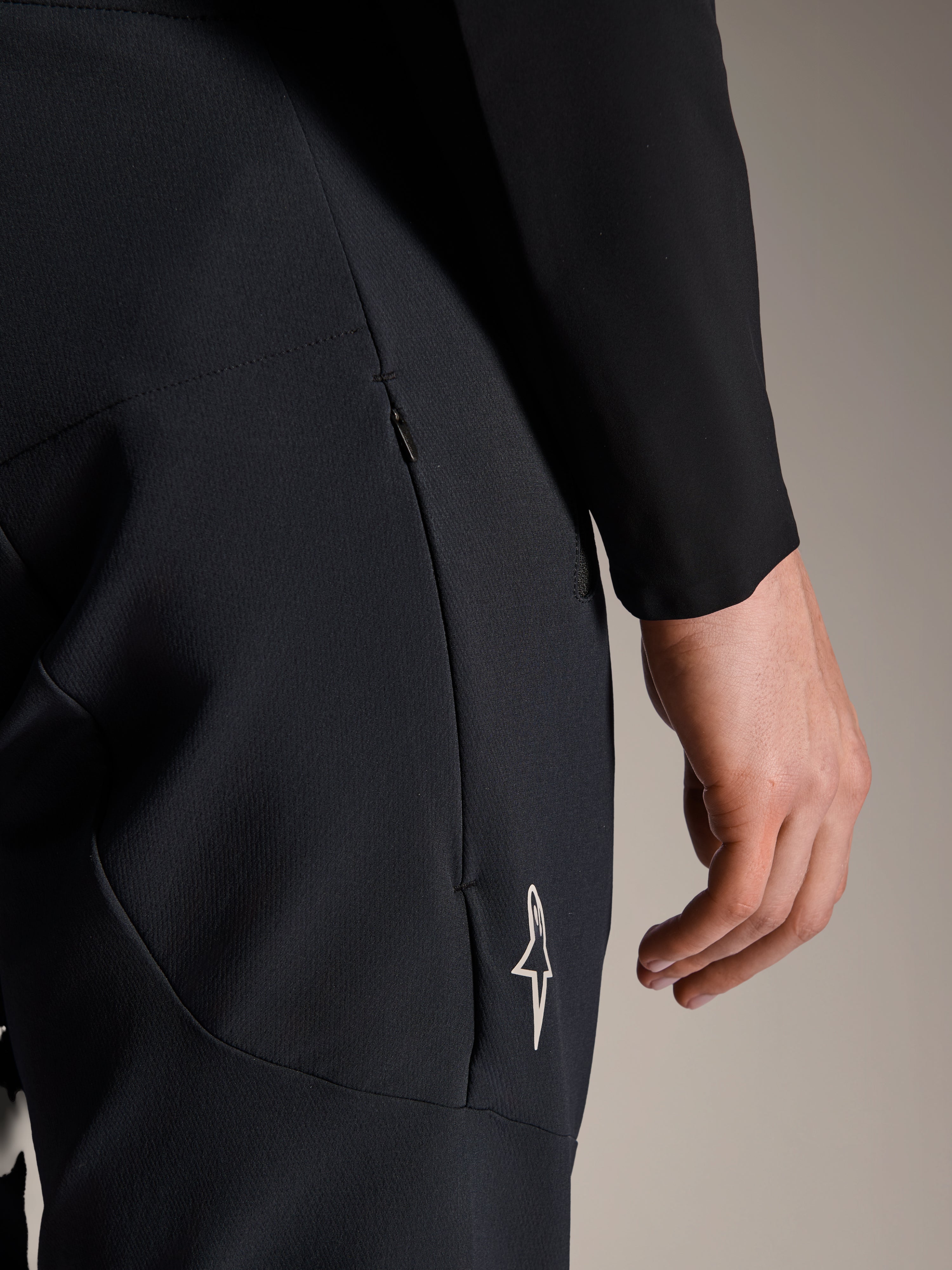 Dettaglio dei pantaloni Alpinestars A-Aria Elite in Black Titanium, con tasca laterale con zip e piccolo logo a stella bianco, pantaloni tecnici da mountain bike progettati per il ciclismo ad alte prestazioni