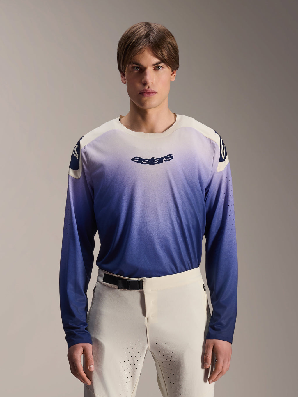 Alpinestars A-Aria Polartec Maker Elite Jersey, maglia MTB a maniche lunghe, Baja Blue con gradiente da bianco a blu, indossata da un modello con pantaloni bianchi, con logo blu scuro sul petto e perforazioni laser sulle maniche, abbigliamento tecnico da mountain bike