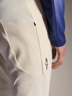 Pantaloni Alpinestars A-Aria Elite, pantaloni tecnici color ecru, vista ravvicinata della tasca laterale con zip e delle perforazioni laser per la ventilazione, dettaglio del logo minimalista, tessuto ad alta elasticità per mountain bike