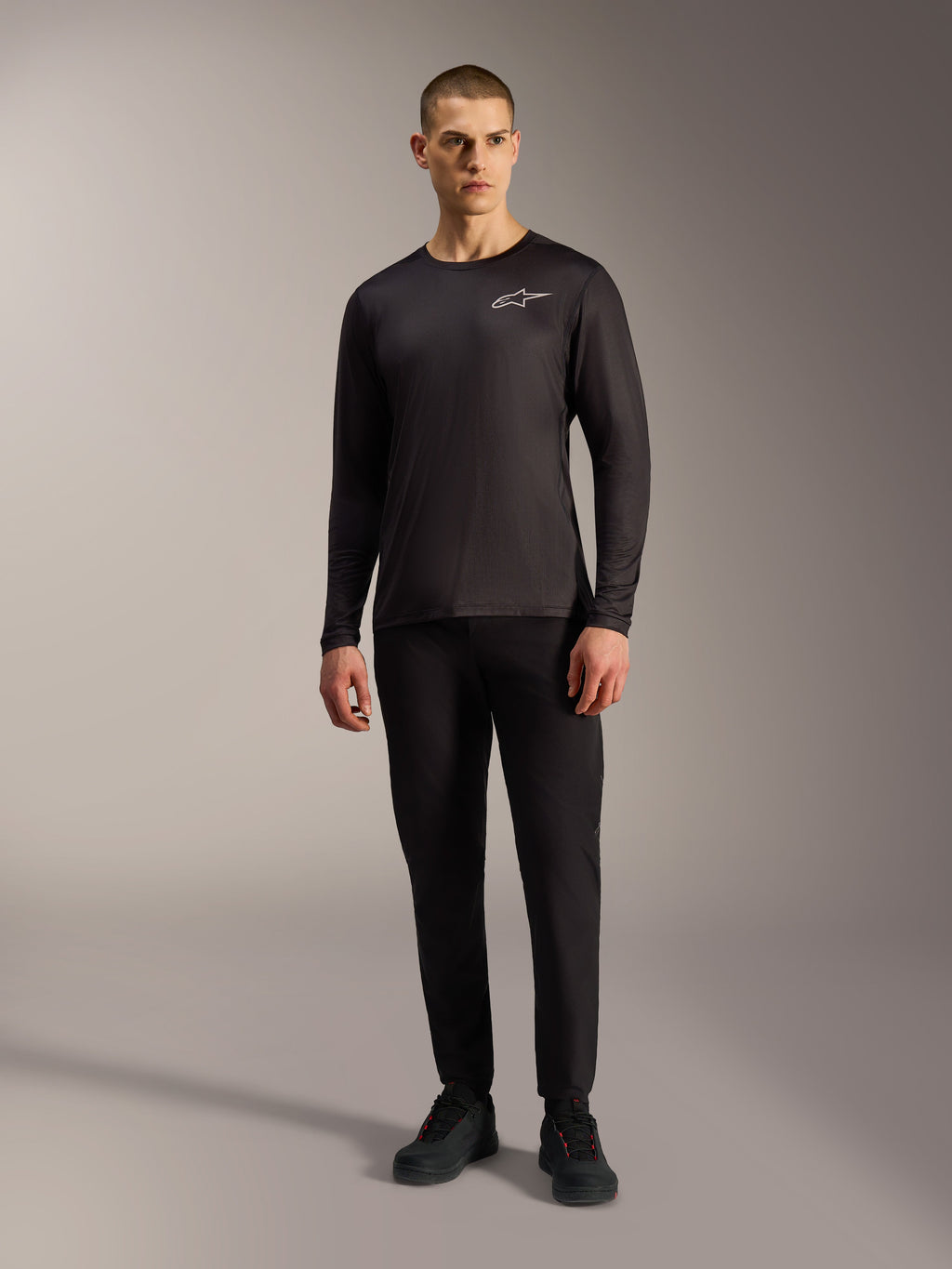 Maglia A-Dura Air nera a maniche lunghe, abbigliamento MTB traspirante con logo Alpinestars bianco su un modello.