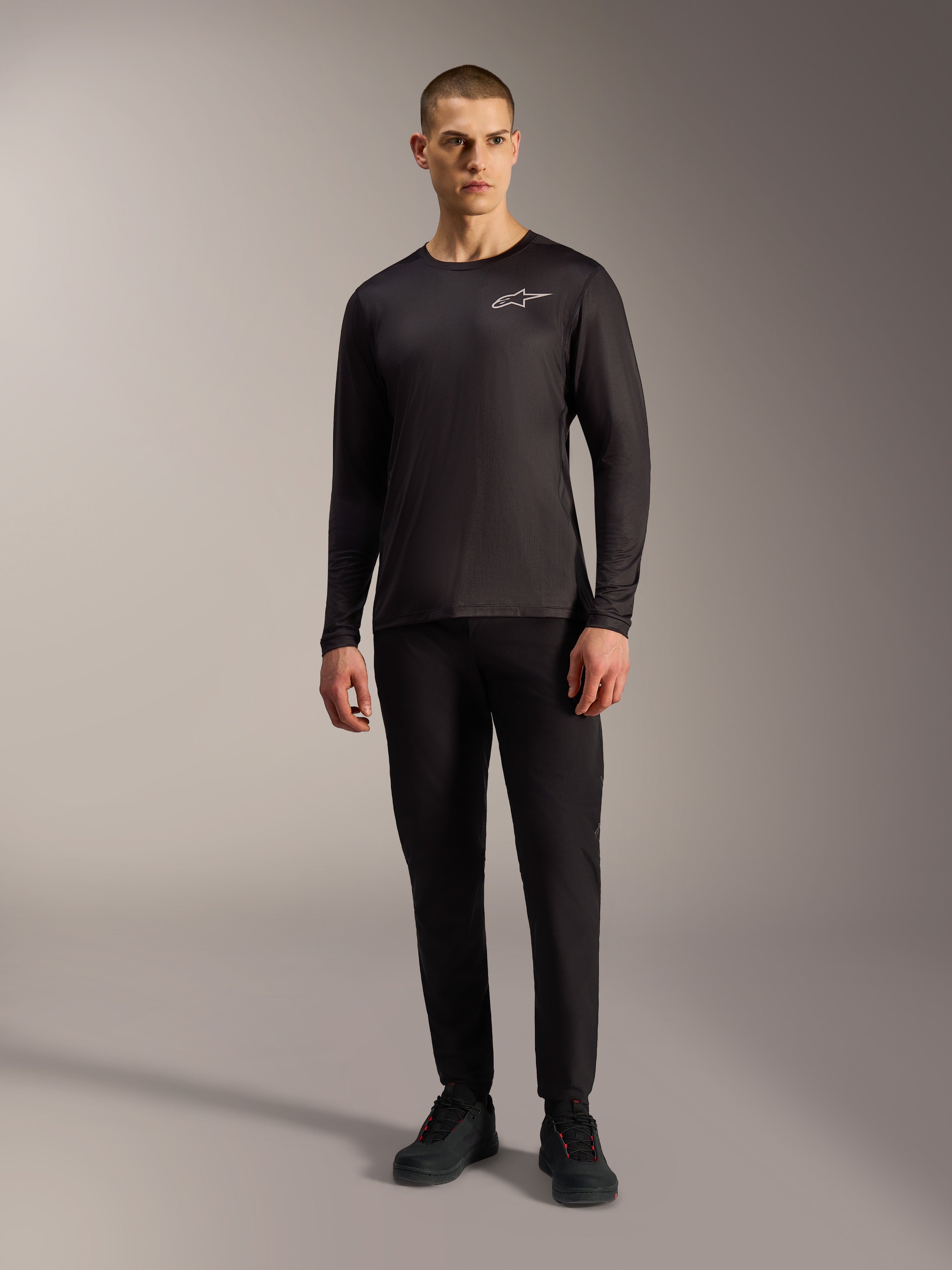 Maglia A-Dura Air nera a maniche lunghe, abbigliamento MTB traspirante con logo Alpinestars bianco su un modello.