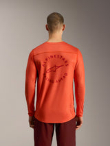 Maglia Alpinestars A-Dura Air arancione a maniche lunghe con grafica circolare Racing Ahead sul retro e mesh traspirante.