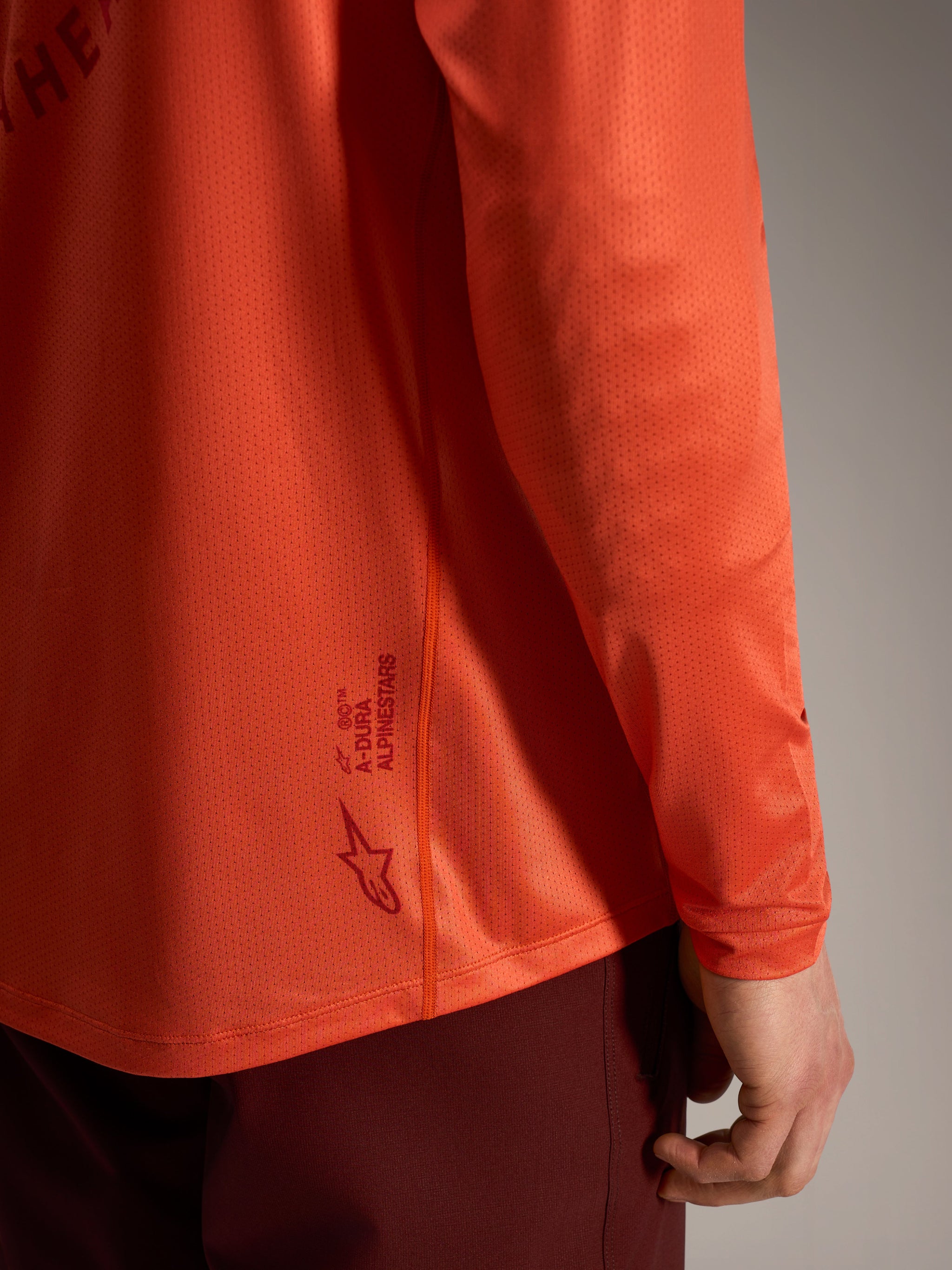 Maglia MTB A-Dura Air arancione a maniche lunghe, mini mesh traspirante e logo Alpinestars sul retro.