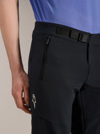 Alpinestars A-Aria Elite Shorts, pantaloncini da mountain bike, Black Titanium, con chiusura a fibbia magnetica, tasca con zip e logo Alpinestars bianco, indossati con una maglia da ciclismo blu, abbigliamento tecnico da mountain bike