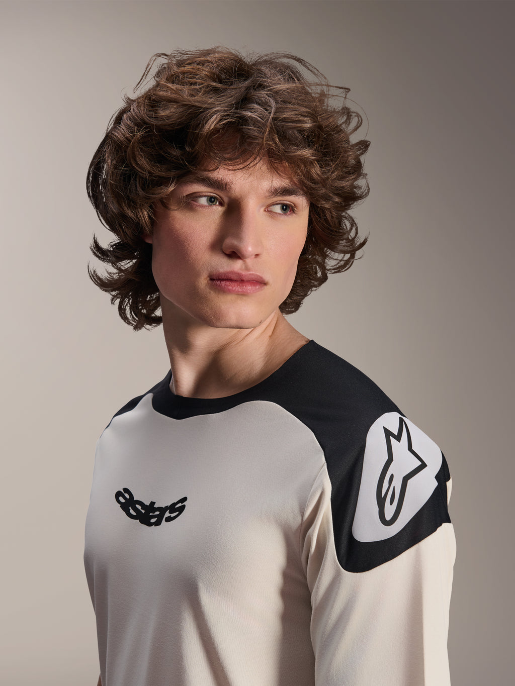Alpinestars Maglia a maniche corte A-Aria Polartec Elite, ecru con pannelli neri sulle spalle, logo astars nero sul petto e logo Astars bianco sulla spalla, abbigliamento da mountain bike ad alte prestazioni indossata da un modello