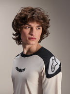 Alpinestars Maglia a maniche corte A-Aria Polartec Elite, ecru con pannelli neri sulle spalle, logo astars nero sul petto e logo Astars bianco sulla spalla, abbigliamento da mountain bike ad alte prestazioni indossata da un modello