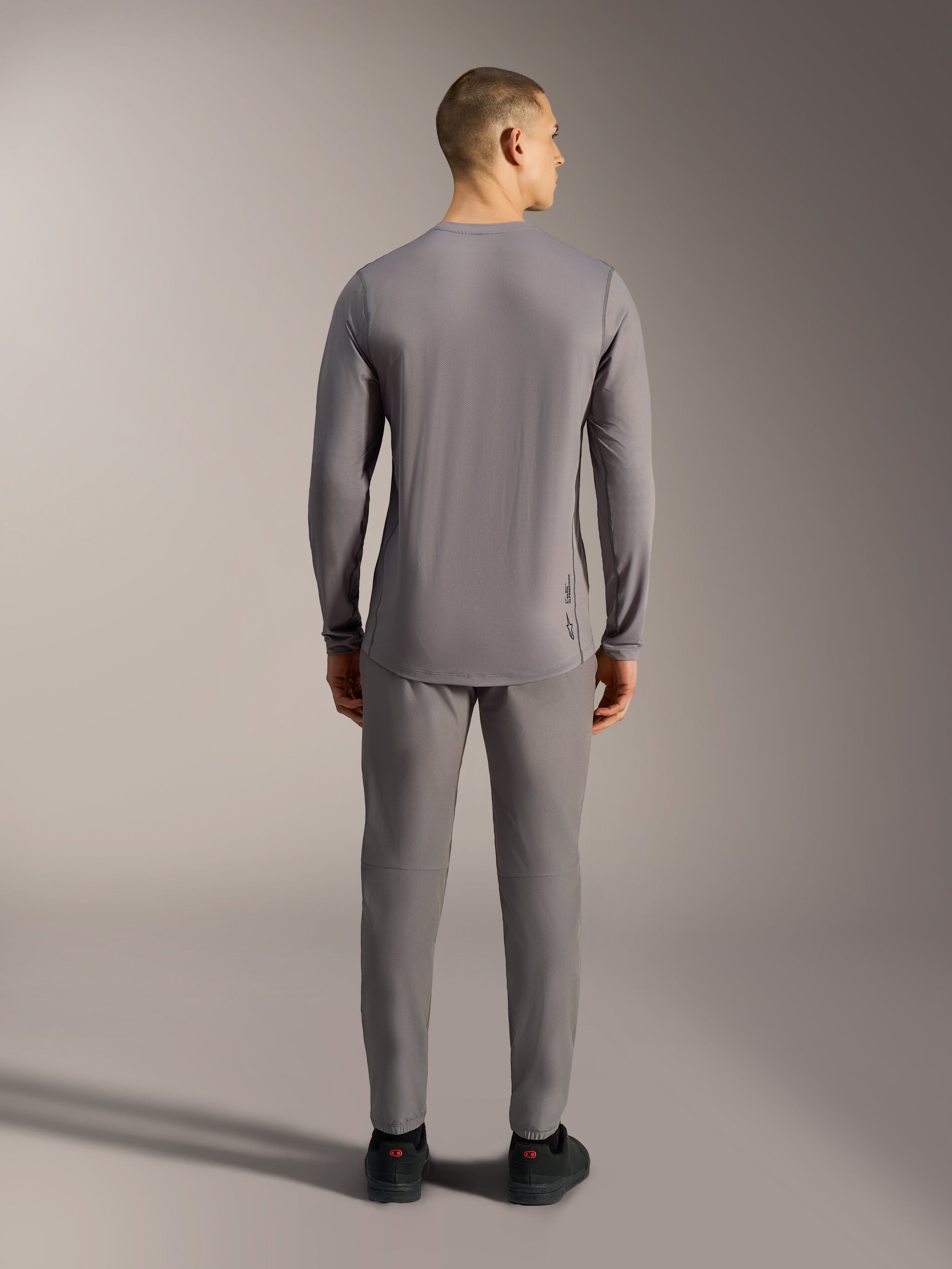 Maglia Alpinestars A-Dura Ride grigia a maniche lunghe, capo da MTB in tessuto jacquard tecnico con coda allungata.