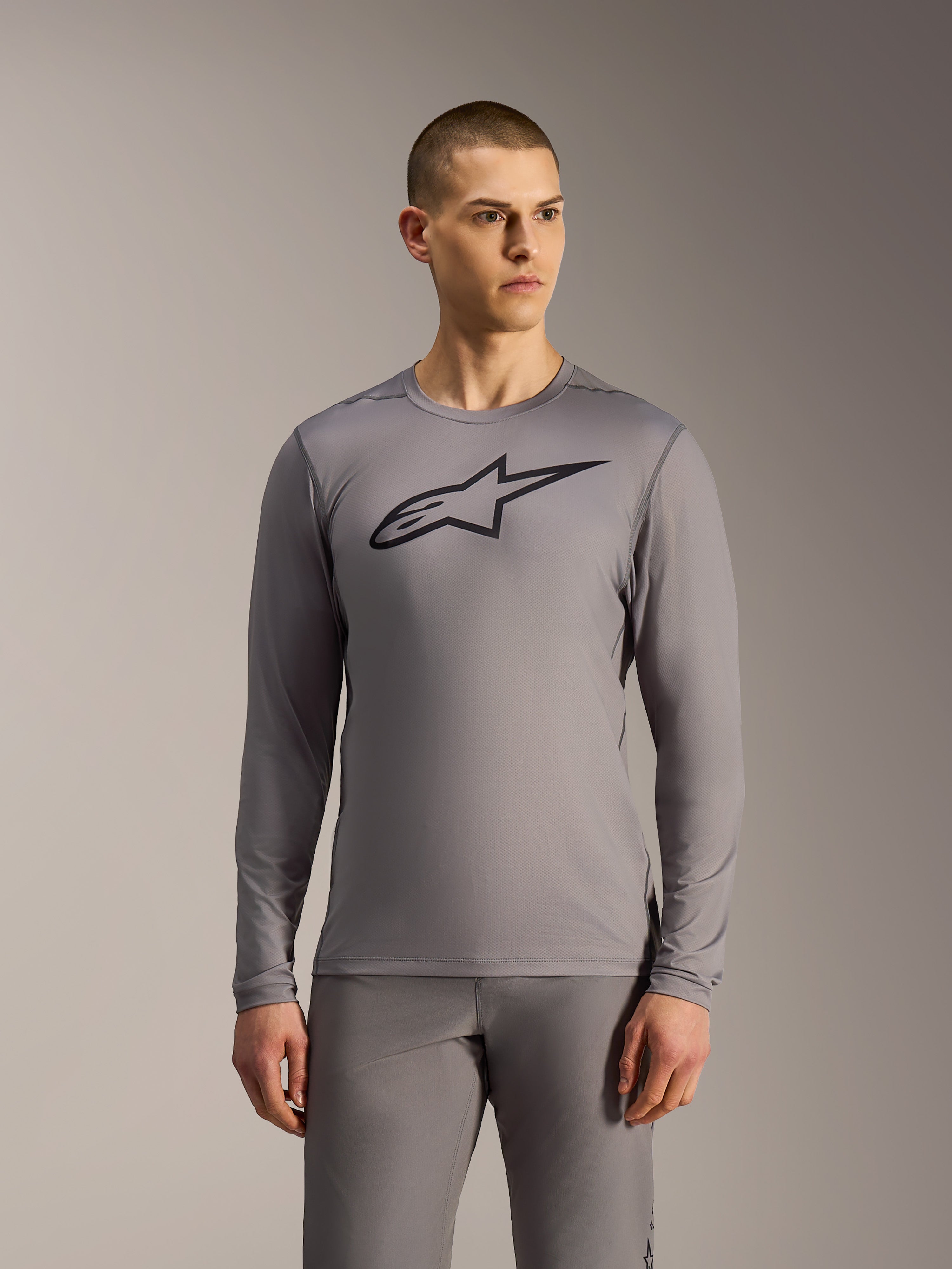 Maglia MTB Alpinestars A-Dura Ride grigia a maniche lunghe, con logo nero sul petto e struttura in mesh tecnica.