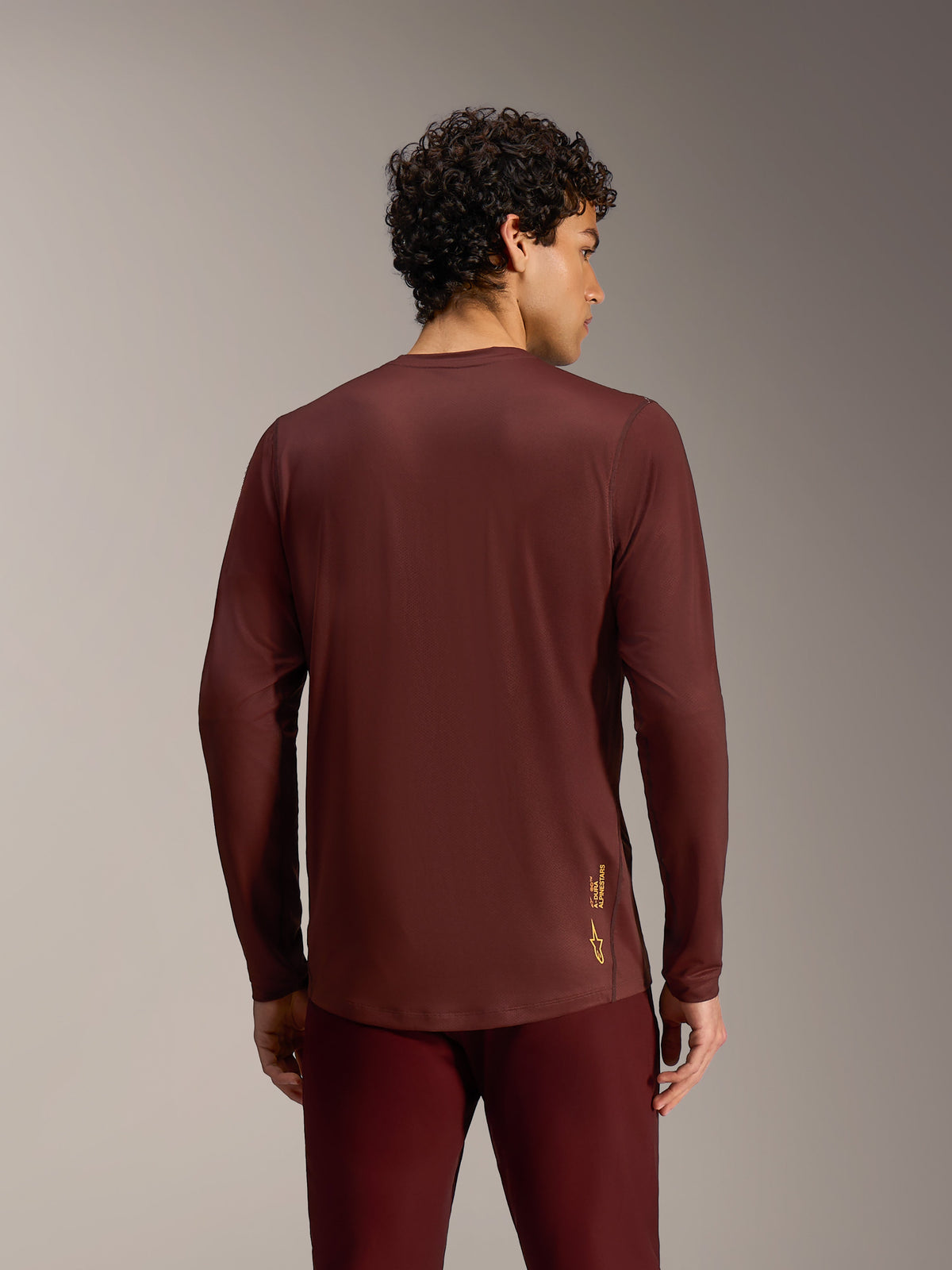 Alpinestars A-Dura Ride Maglia bordeaux a maniche lunghe, vista posteriore con tessuto tecnico e orlo allungato.