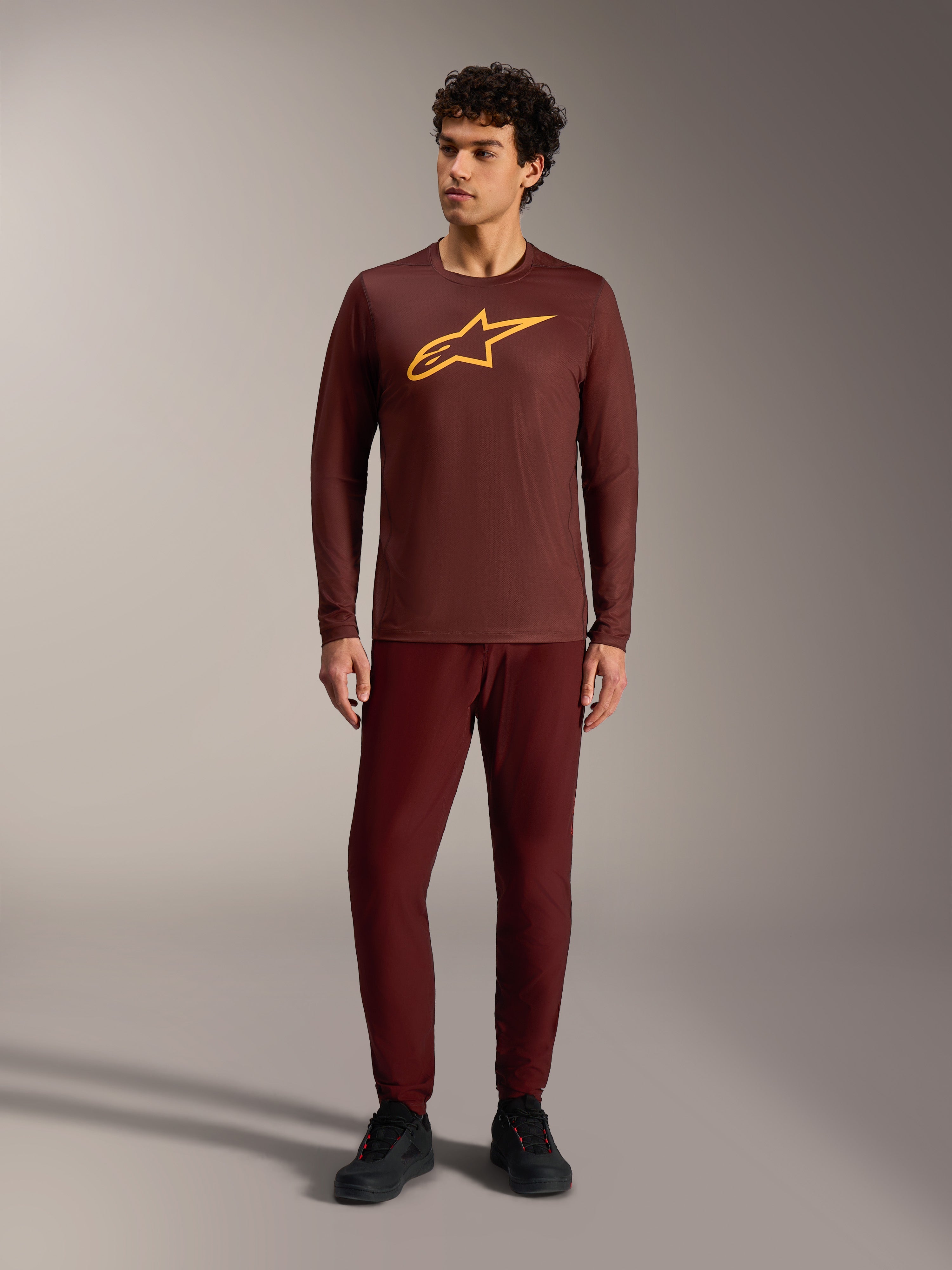 Maglia a maniche lunghe A-Dura Ride bordeaux con logo Alpinestars giallo e pantaloni coordinati per MTB trail.
