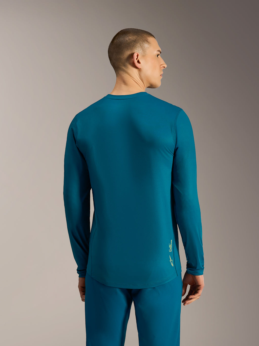 Maglia Alpinestars A-Dura Ride blu verde a maniche lunghe con coda allungata e logo per performance MTB.