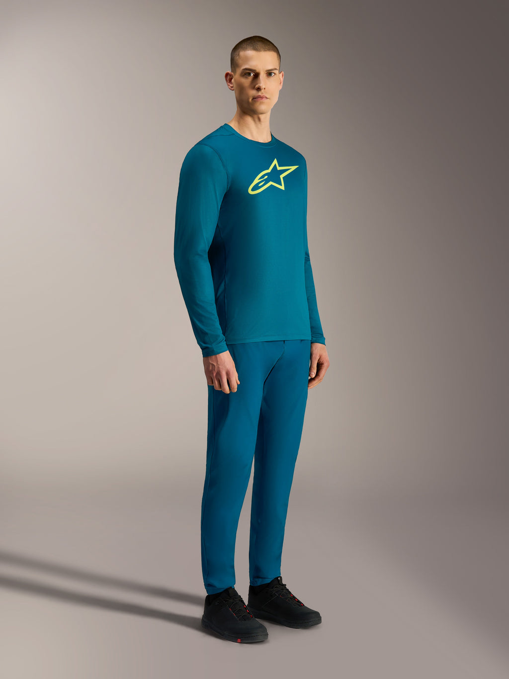 Maglia A-Dura Ride a maniche lunghe blu verde, logo Astars giallo, abbigliamento tecnico MTB coordinato.