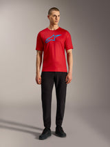Maglia Alpinestars A-Dura Ride rossa con logo blu, abbinata a pantaloni neri per un look MTB casual.