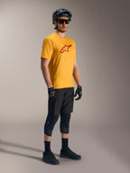 Maglia A-Dura Ride arancione con logo Astars rosso, abbinata a casco e attrezzatura tecnica da MTB neri.