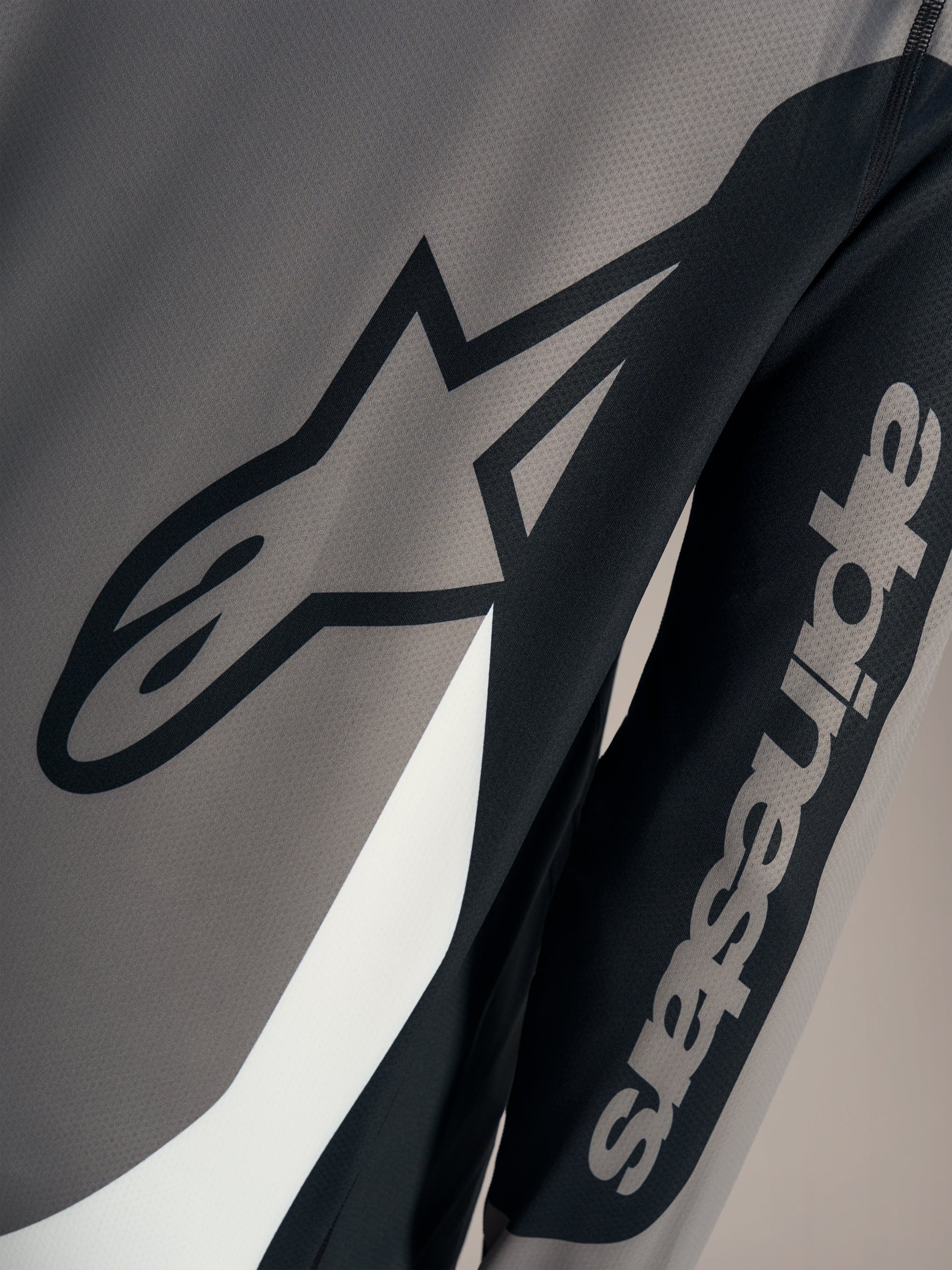 Maglia Alpinestars A-Dura Race grigia, dettaglio loghi neri su tessuto mesh tecnico traspirante per mountain bike.