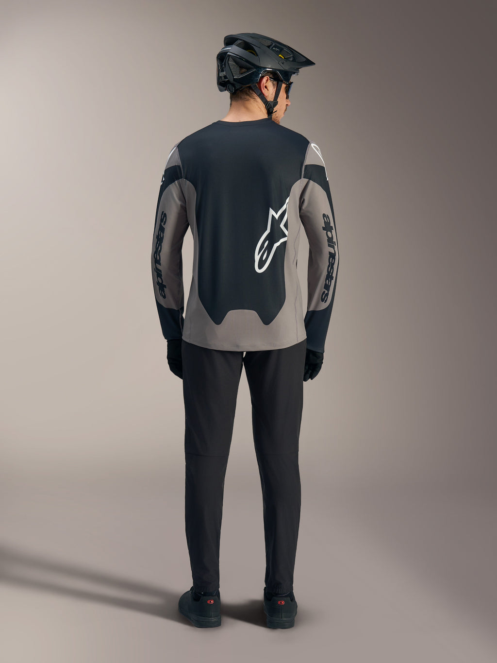 Maglia A-Dura Race grigia a maniche lunghe, vista posteriore con pannelli neri e loghi Alpinestars bianchi per MTB.
