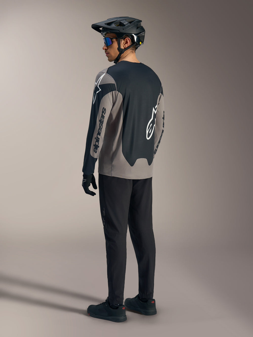Maglia A-Dura Race a maniche lunghe grigia e nera Alpinestars, vista posteriore in un kit completo da MTB.