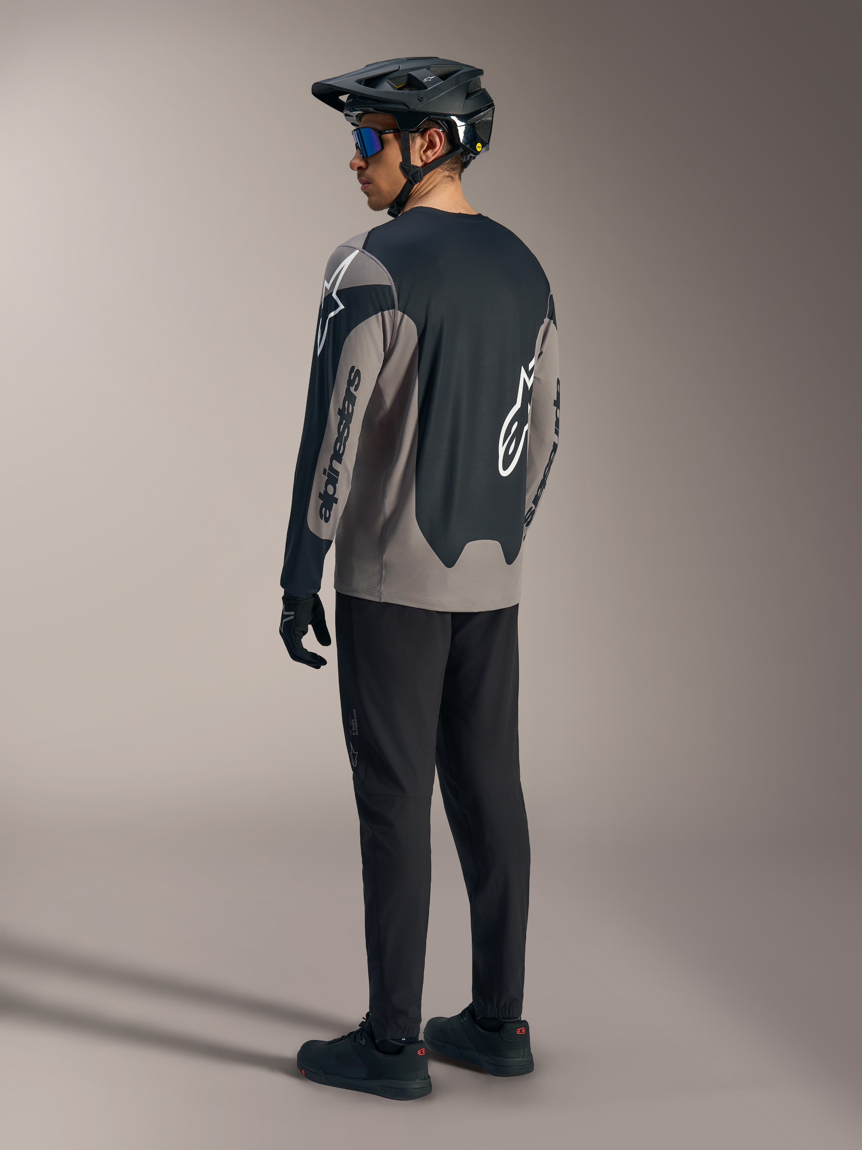 Maglia A-Dura Race a maniche lunghe grigia e nera Alpinestars, vista posteriore in un kit completo da MTB.