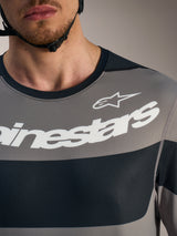 Maglia Alpinestars A-Dura Race grigia, dettaglio petto con loghi bianchi e tessuto tecnico traspirante.